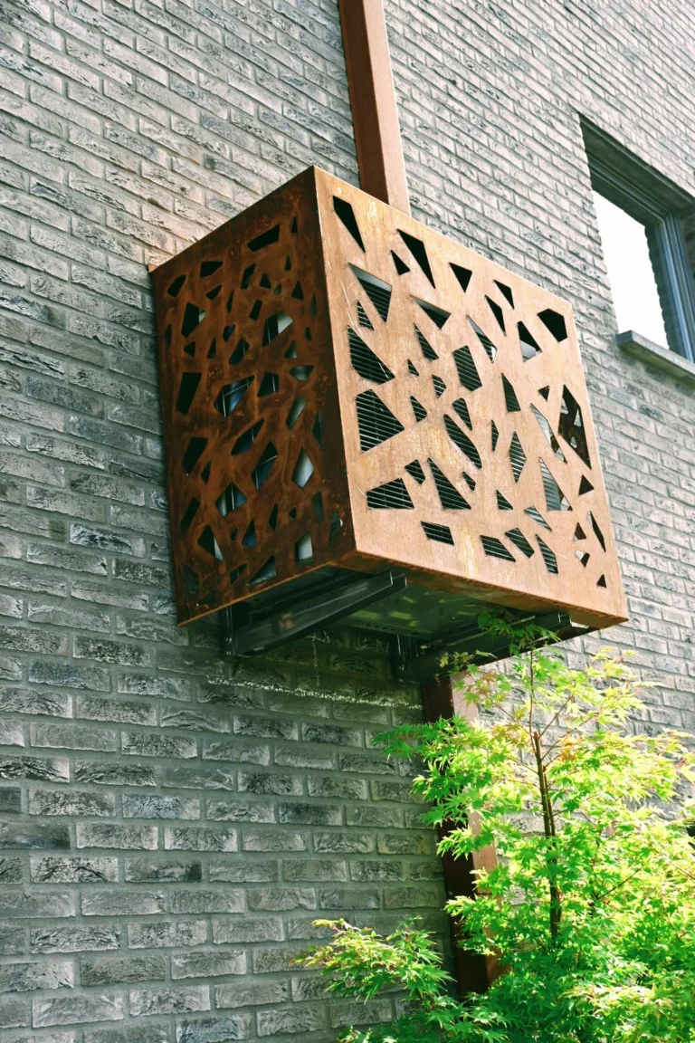 Airco-omkasting in cortenstaal met uitgesneden patroon