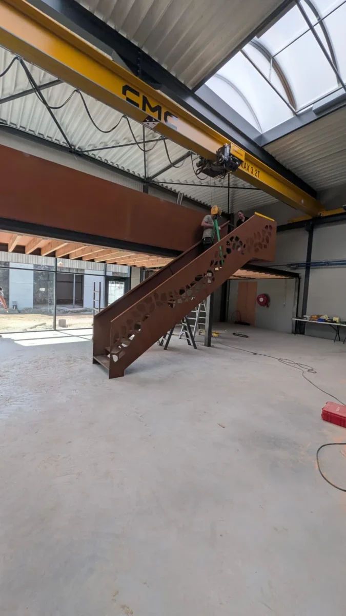 Trap met uitgesneden wangen in cortenstaal naar de mezzanine